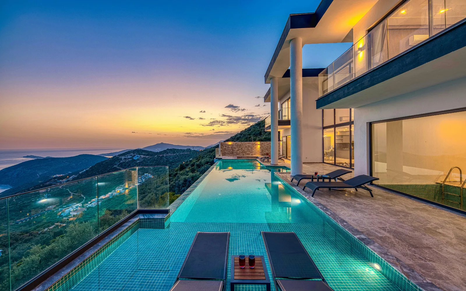 Villa et piscine à débordement au soleil couchant