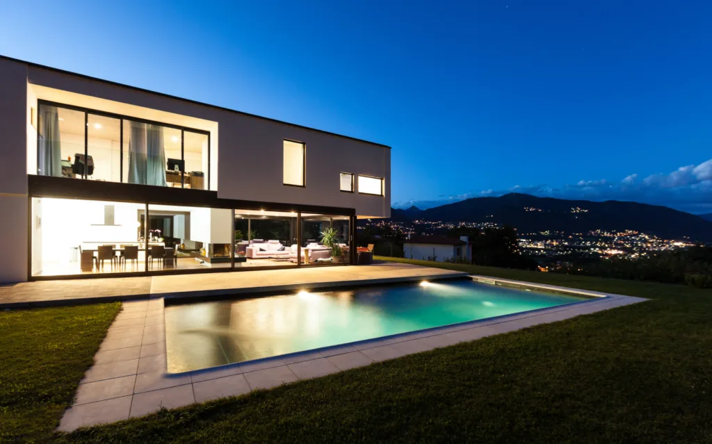 Villa au crépuscule, piscine éclairée et vue sur les collines
