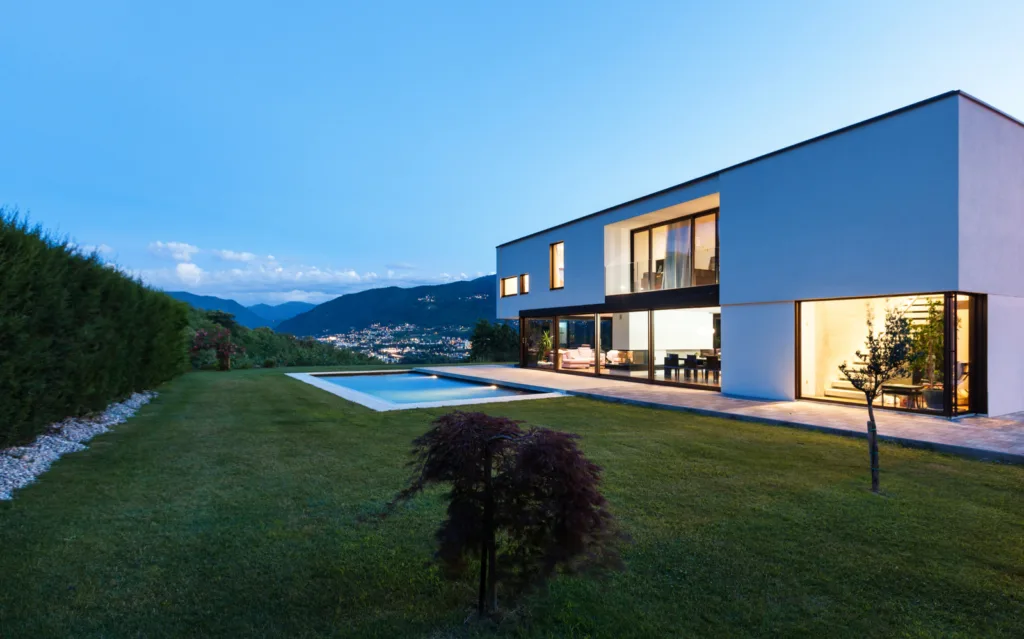 Maison contemporaine posée sur une pelouse, ciel dégagé