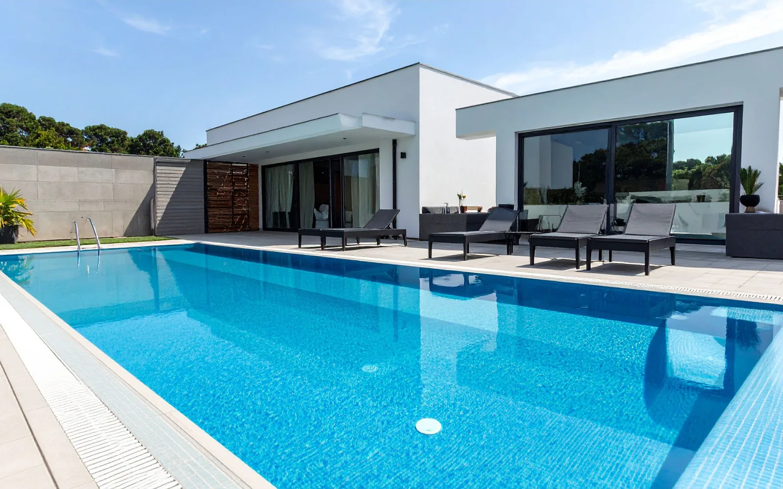 Maison d'architecte et sa piscine longée d'un mur de soutènement